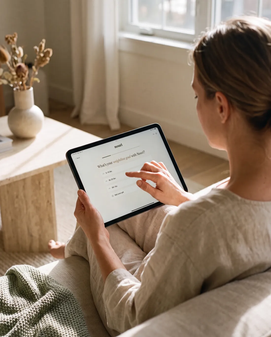 A person completes Nouri's online health questionnaire on a tablet at home.