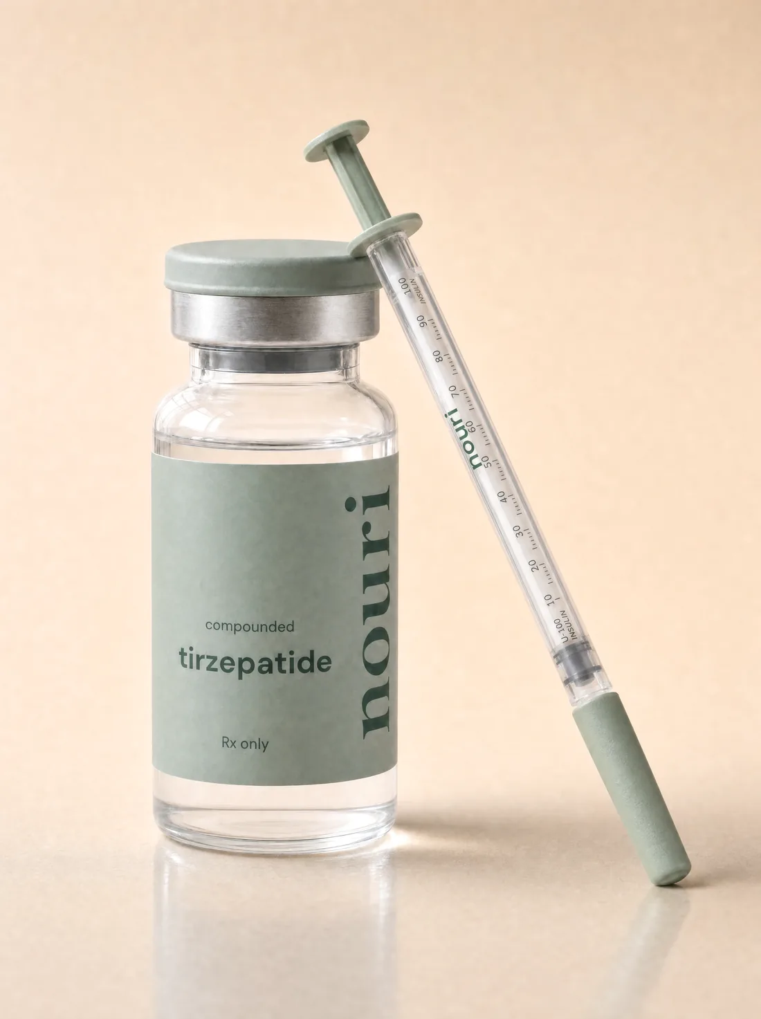 A Nouri compounded tirzepatide vial with a U-100 insulin syringe — the concentration on the label sets the units.